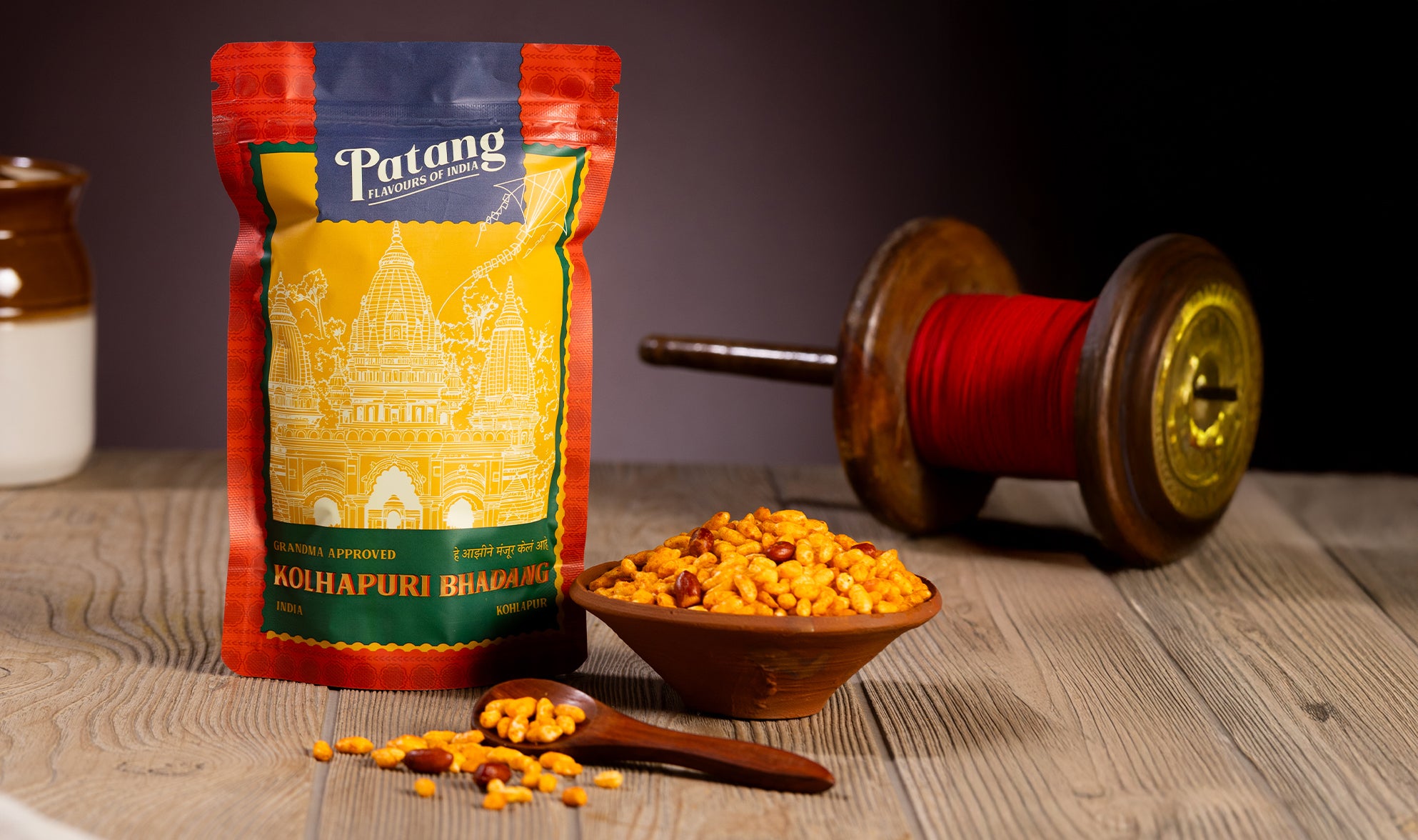 Patang Bolhnapuri Bhelpuri Spice Pack on a wooden surface with spices and a wooden spoon.