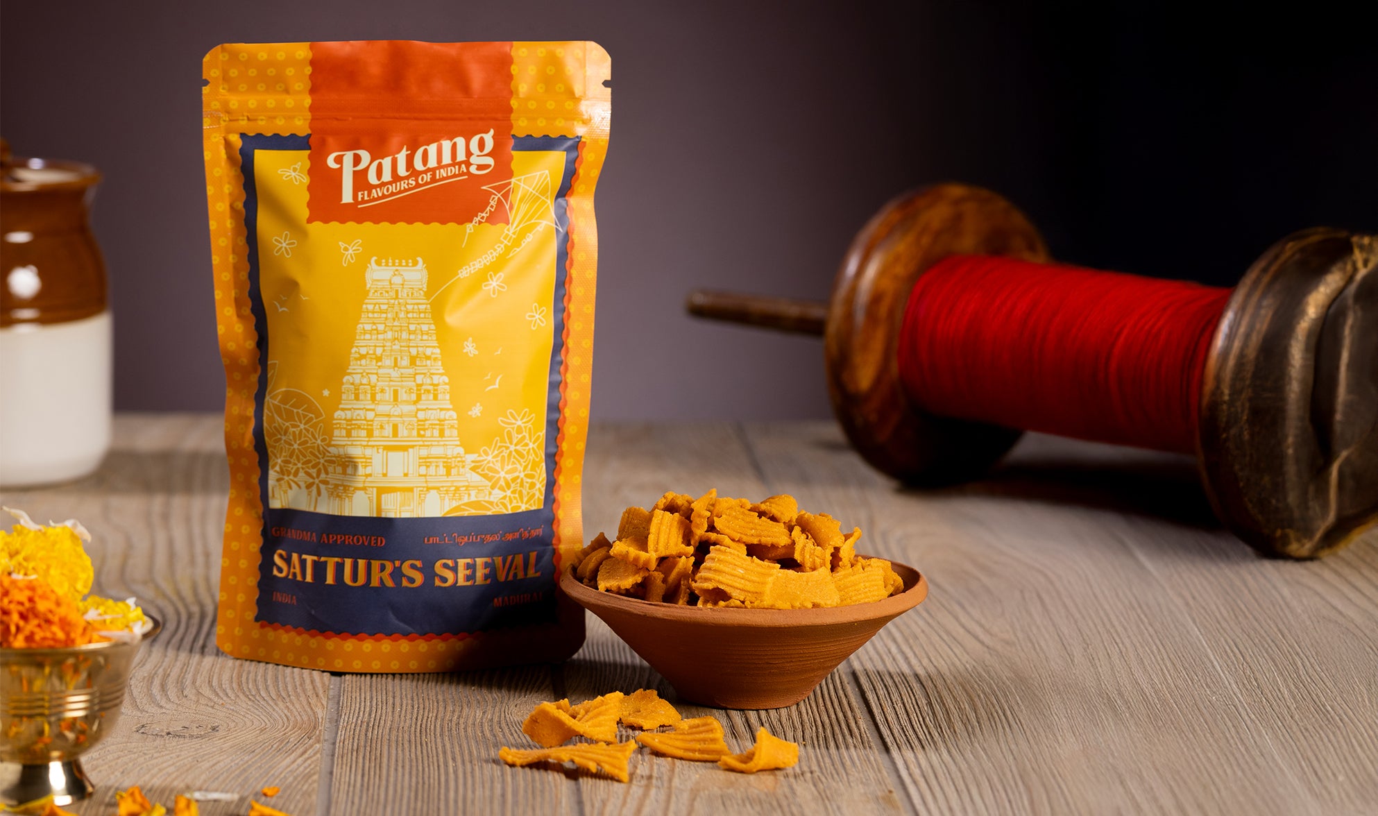 Packaged food product with a bowl of snacks on a wooden surface